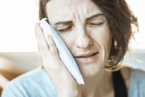 Woman holding her jaw because of TMJ pain